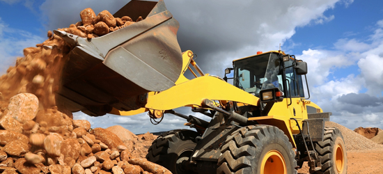 A loader dumps dirt at a clean up site for a Brownfields project