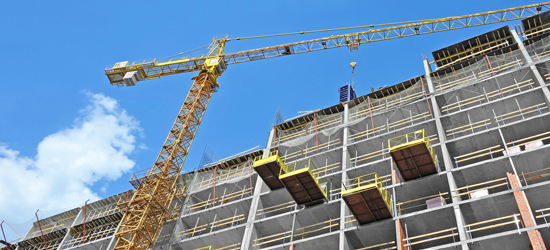 A building under construction with a large crane in the front of it