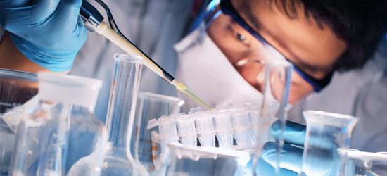 A researcher adds a substance to a rack of test tubes