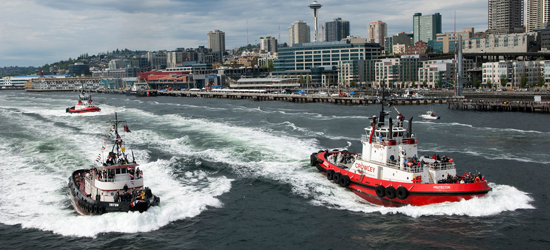 Tugs race along the Seattle waterfront.