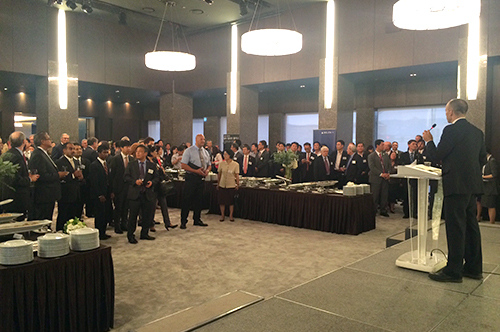 Delegates and partners listen to an address by Commerce Director Brian Bonlender