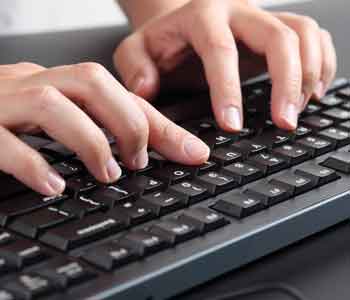 A person types words on a black keyboard