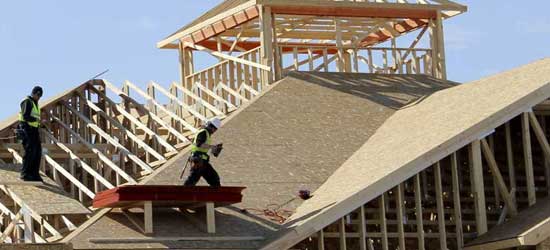 Workers add framing to a new housing project