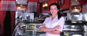 A baker owner poses in her shop