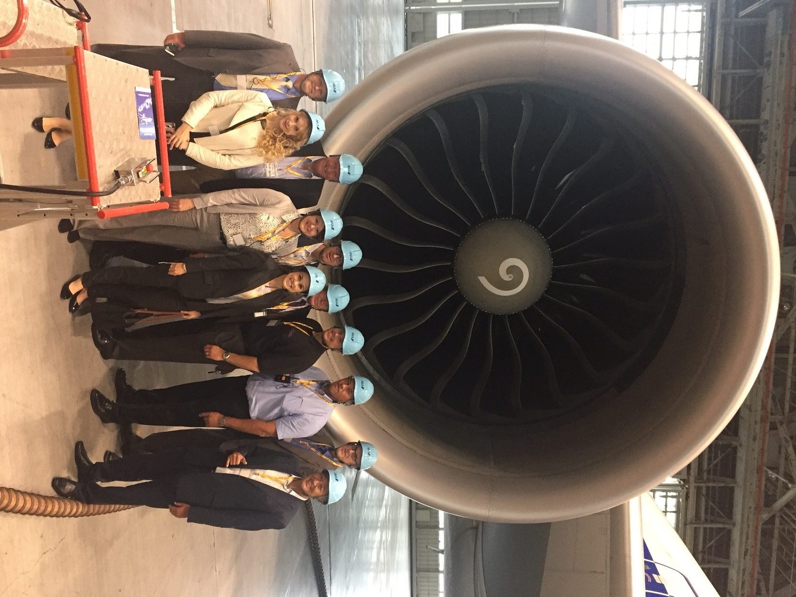 Photo of members of Washington State trade delegation standing near jet engine in Tokyo Japan