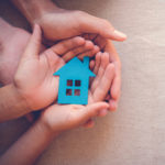 Young hands holding dream of affordable home