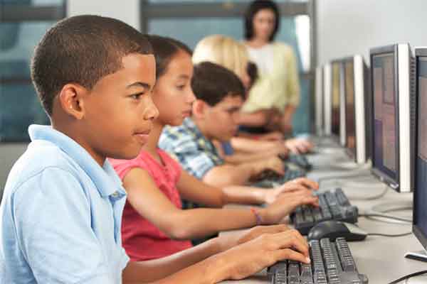 Junior high students sitting in front of computers in classroom setting