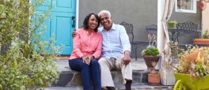 Couple sitting on porch in front of affordable home