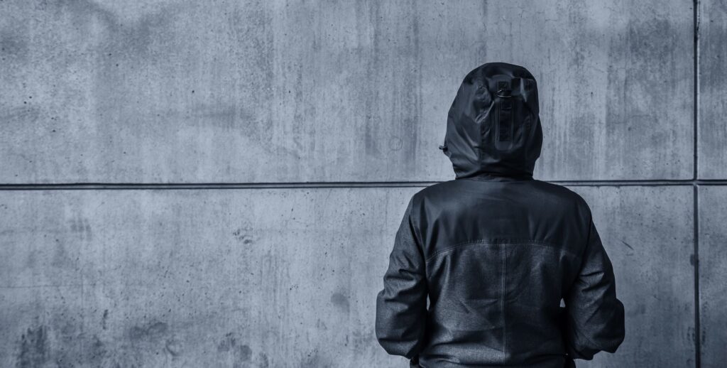 Young adult woman facing wall