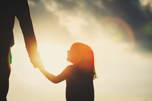 Little girl holding adults hand