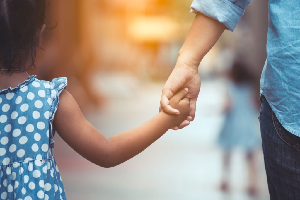 Parent holding child's hand