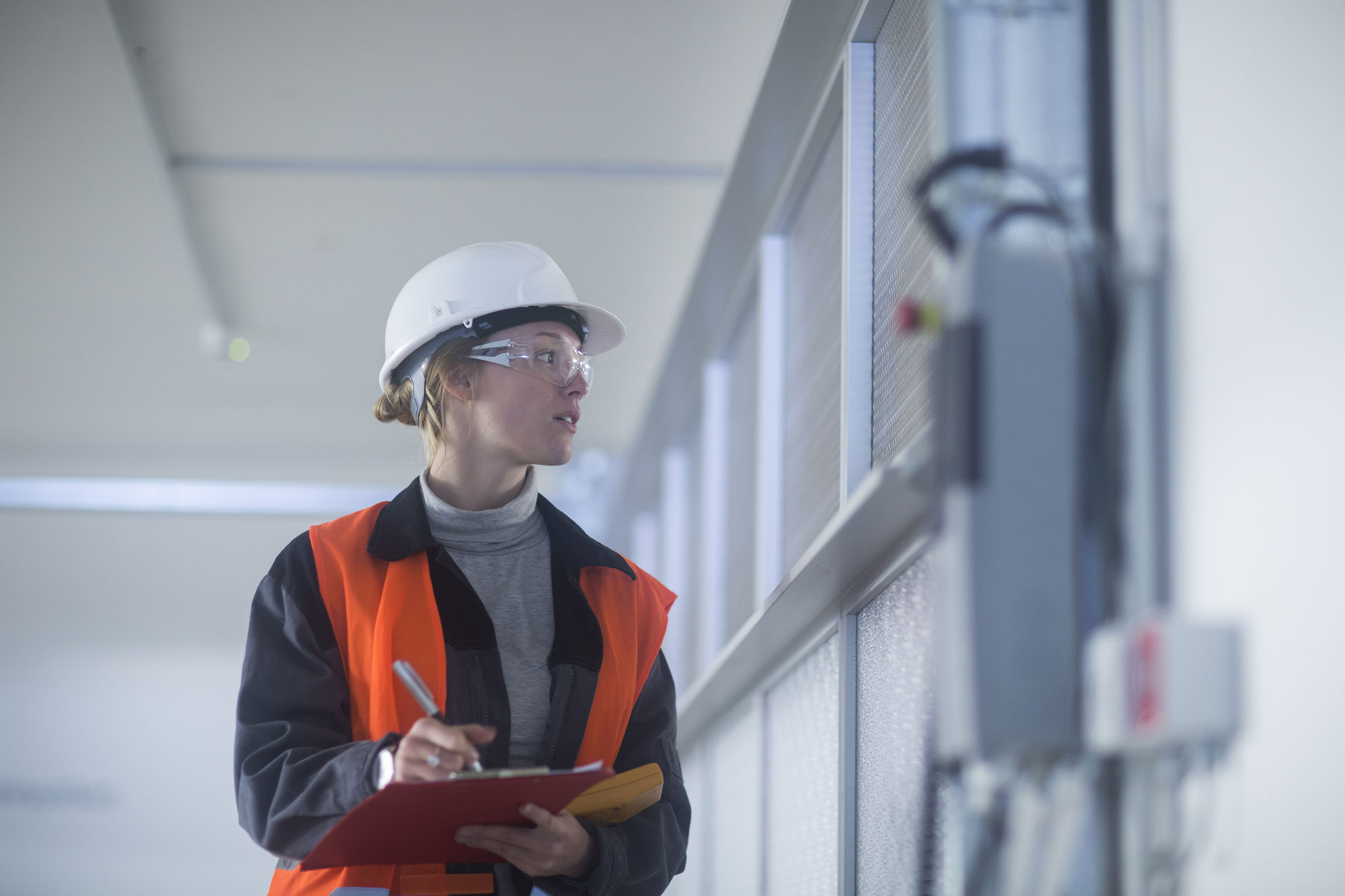 Worker recording data from building metering equipment