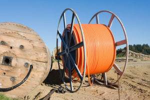 Orange roll of broadband cable in field.