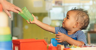 Child reaching for bottle of water