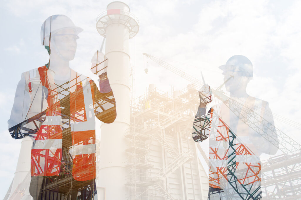 Engineers holding portable radios and wearing helmets and orange vests