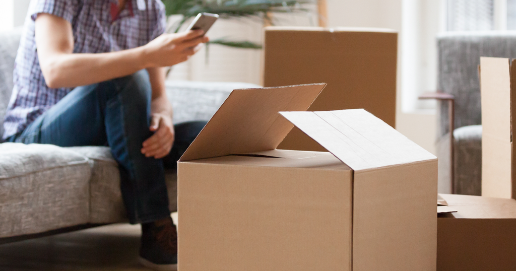 Hombre sentado junto a cajas de mudanza en el apartamento