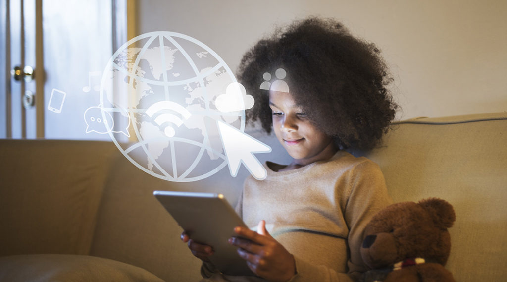 Black girl using iPad on a couch