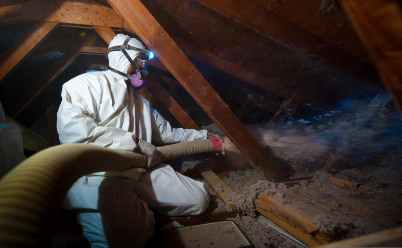 individual installing insulation in a attic
