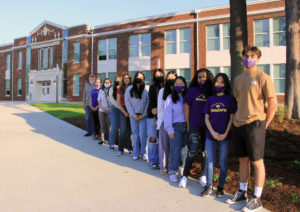 Photo of members of Highline High School Environmental Club with advisers and community partners standing in front of the new school