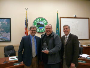 Photo of award in council chambers with leadership and staff