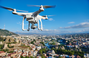 Photo of a drone in flight over a town