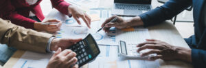 Picture of diagrams, calculator and hands of people working