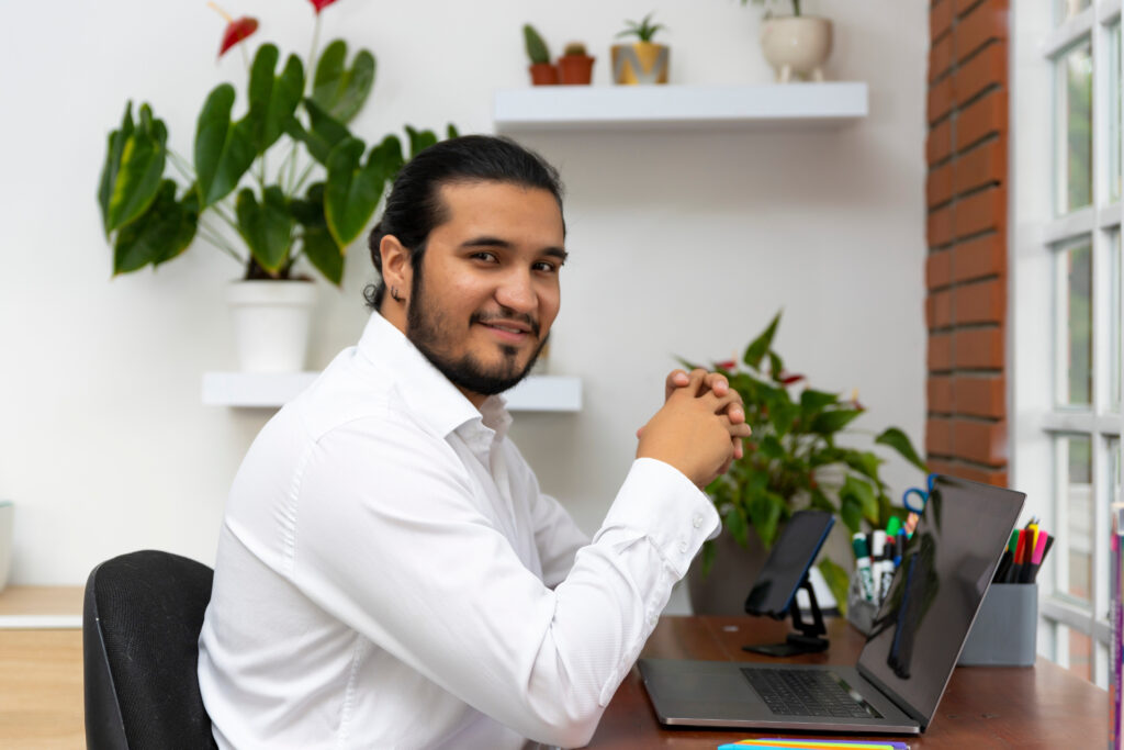 Young latino man working at home in a desk. Home office concept