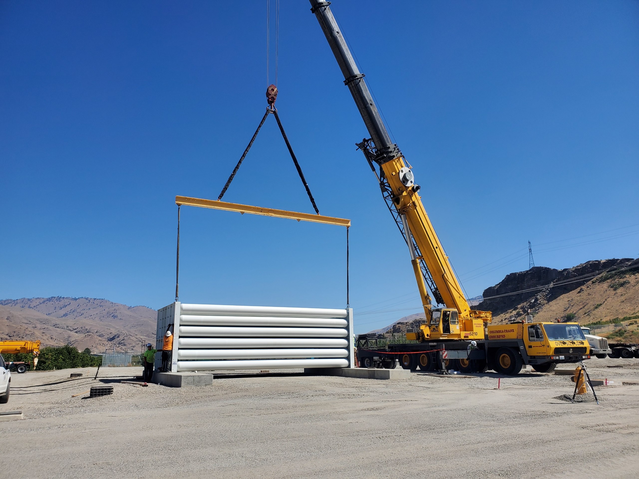 Crane operators install storage vessels for a green hydrogen plant in East Wenatchee.