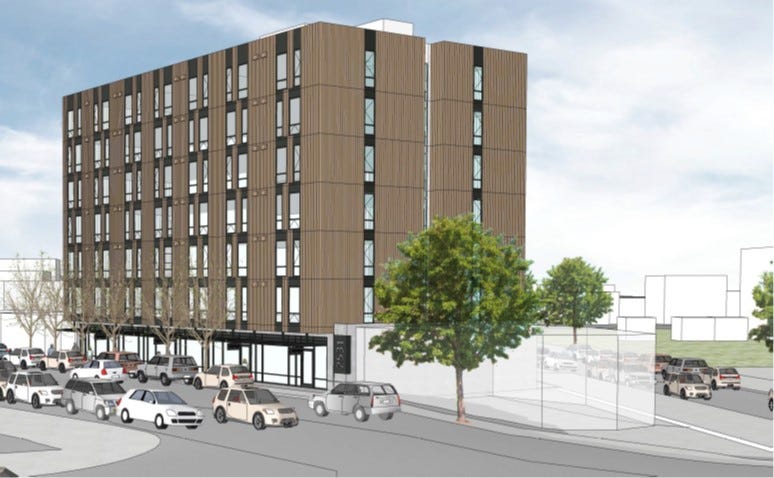 A rendering of an affordable housing complex in Seattle's Beacon Hill neighborhood shows a seven story building between two streets with green space around.