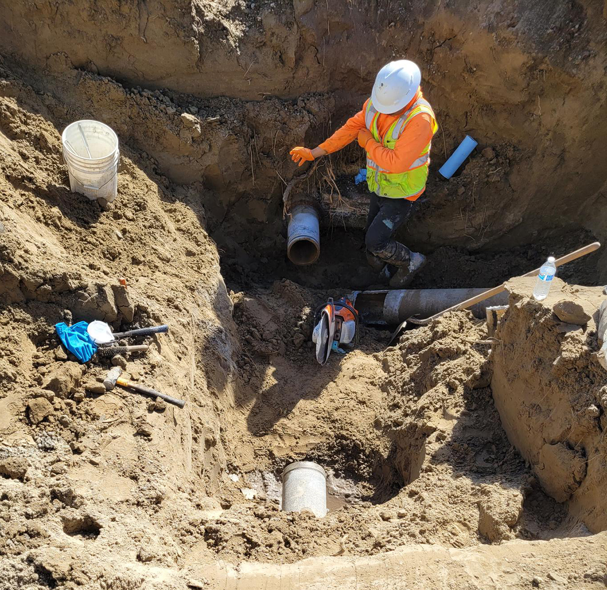 A worker in a dirt ditch. 